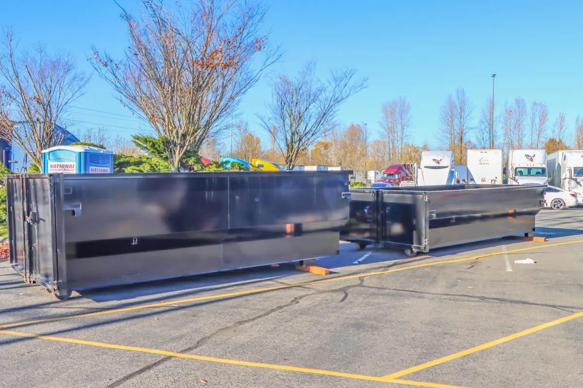 Professional dumpster rental service with roll-off container on residential driveway in University Park